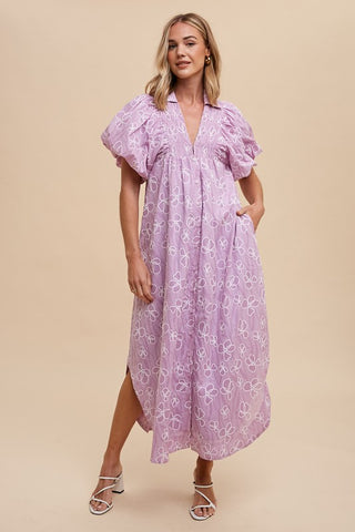 Pink and purple floral smocked puff sleeve midi dress with modest side slit, model with hand in pocket