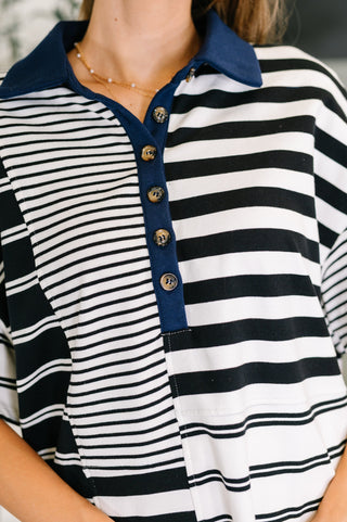 Close-up of a person wearing a cotton black and white striped shirt with a blue collar.