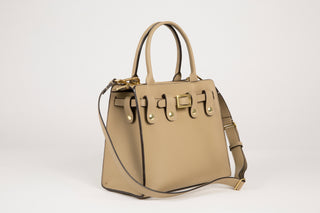 Three quarter view of Lavāda vegan leather Signature interchangeable Handbag in tan. Base bag comes with   interchangeable belt, outer cover, and carrying strap (not pictured)