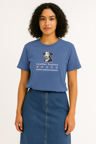 Person wearing a funny vegan, blue t-shirt with a graphic displaying  a cow as a critic giving leather fashion a 1 star rating. 