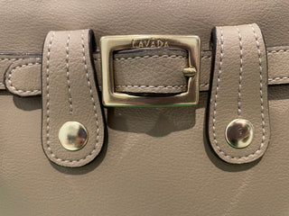 Close up view of Lavāda tan handbag belt and buckle 