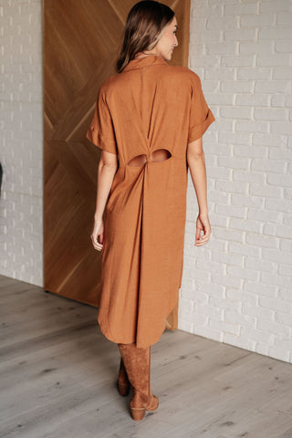 Rear view of woman wearing a brown dress with unique back waist detail 