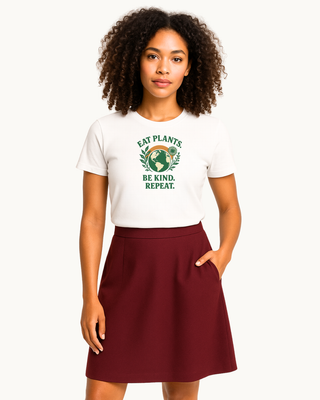 Model wearing white graphic tshirt that reads "Eat plants, be kind, repeat." 100% cotton. Eco friendly