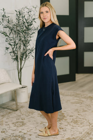Side profile of woman wearing a navy midi dress, 95% cotton
