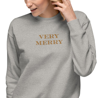 closeup of model wearing gold embroidered Very Merry sweatshirt in carbon gray