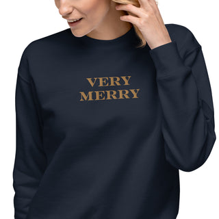 closeup of model wearing gold embroidered Very Merry sweatshirt in navy blue